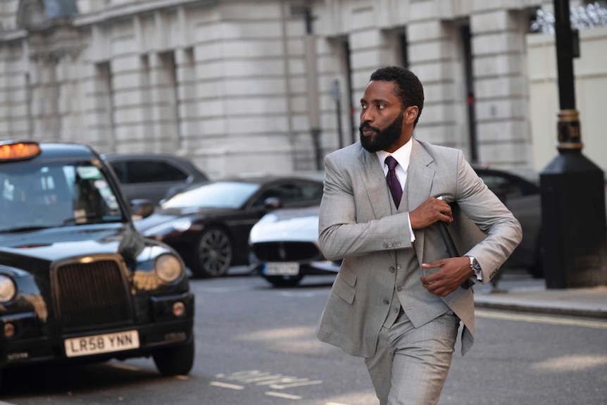 The actor John David Washington crossing a London street in the movie Tenet