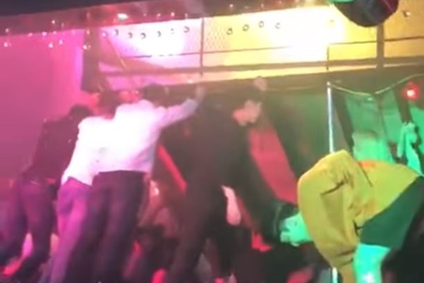 A still from a YouTube video showing people trying to hold up a balcony that collapsed at the Coyote Ugly nightclub.