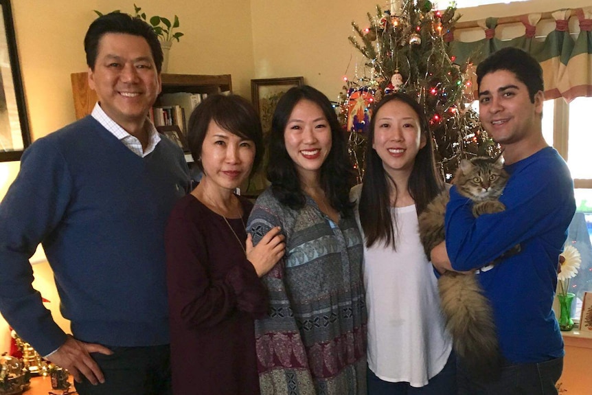 Calvin Chin with his family in front of a Christmas tree.