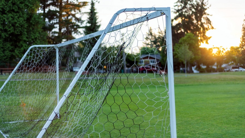 An empty soccer field with no-one in the net.