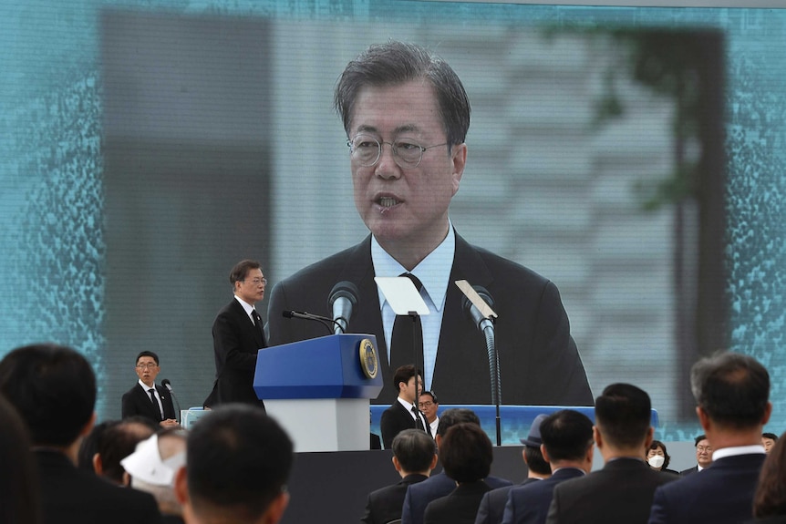 Prezydent Korei Południowej Moon Jae-in przemawia na konferencji przed dużym ekranem LCD.