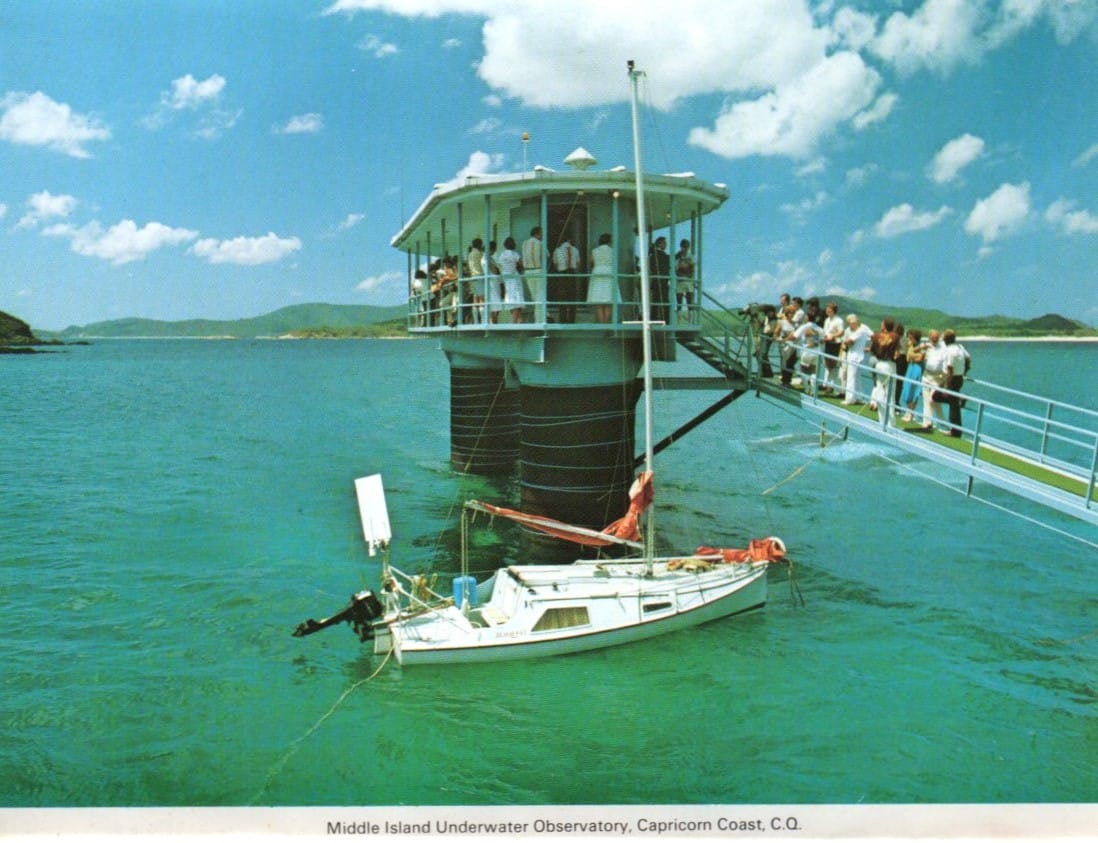 Construindo no oceano, multidões na varanda e na rampa, barco atracado, céu azul claro e nuvens 