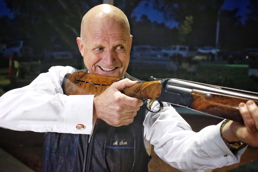 Liberal Democrat Senator David Leyonhjelm poses with a firearm