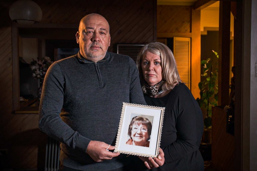 Sam and Suzanne Agnello hold a framed photo of their mother Carmela who died of COVID-19