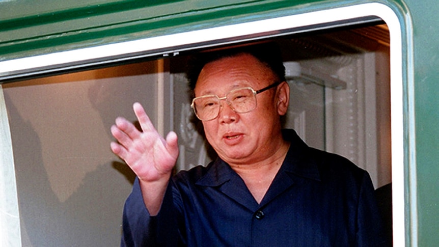 Former North Korean leader Kim Jong-il waves from the open window of his armoured train