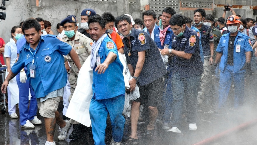 Thai rescue workers remove a body from a hotel after an explosion caused a fire in Hat Yai district, Songkhla province.