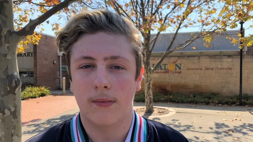 A teenage boy in a school jacket outside Eaton Community College