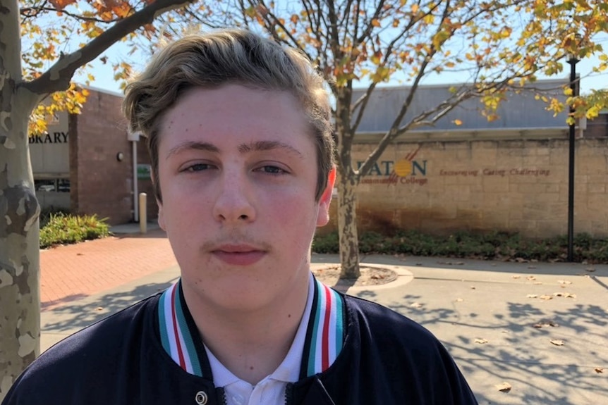 A teenage boy in a school jacket outside Eaton Community College