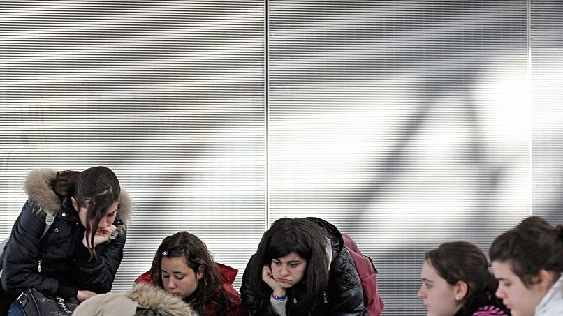 Passengers sit on the floor of Heathrow Airport's Terminal 5