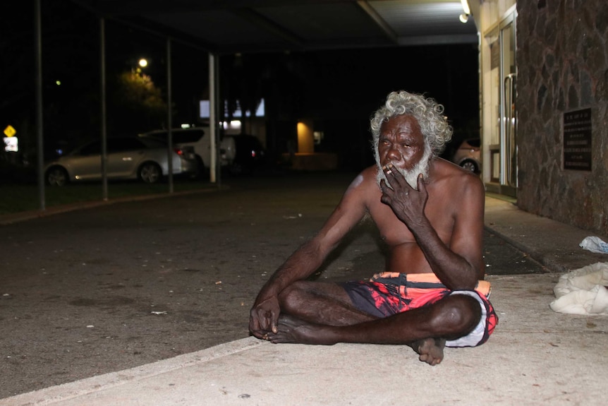 Homeless Aboriginal man sits on a Darwin street