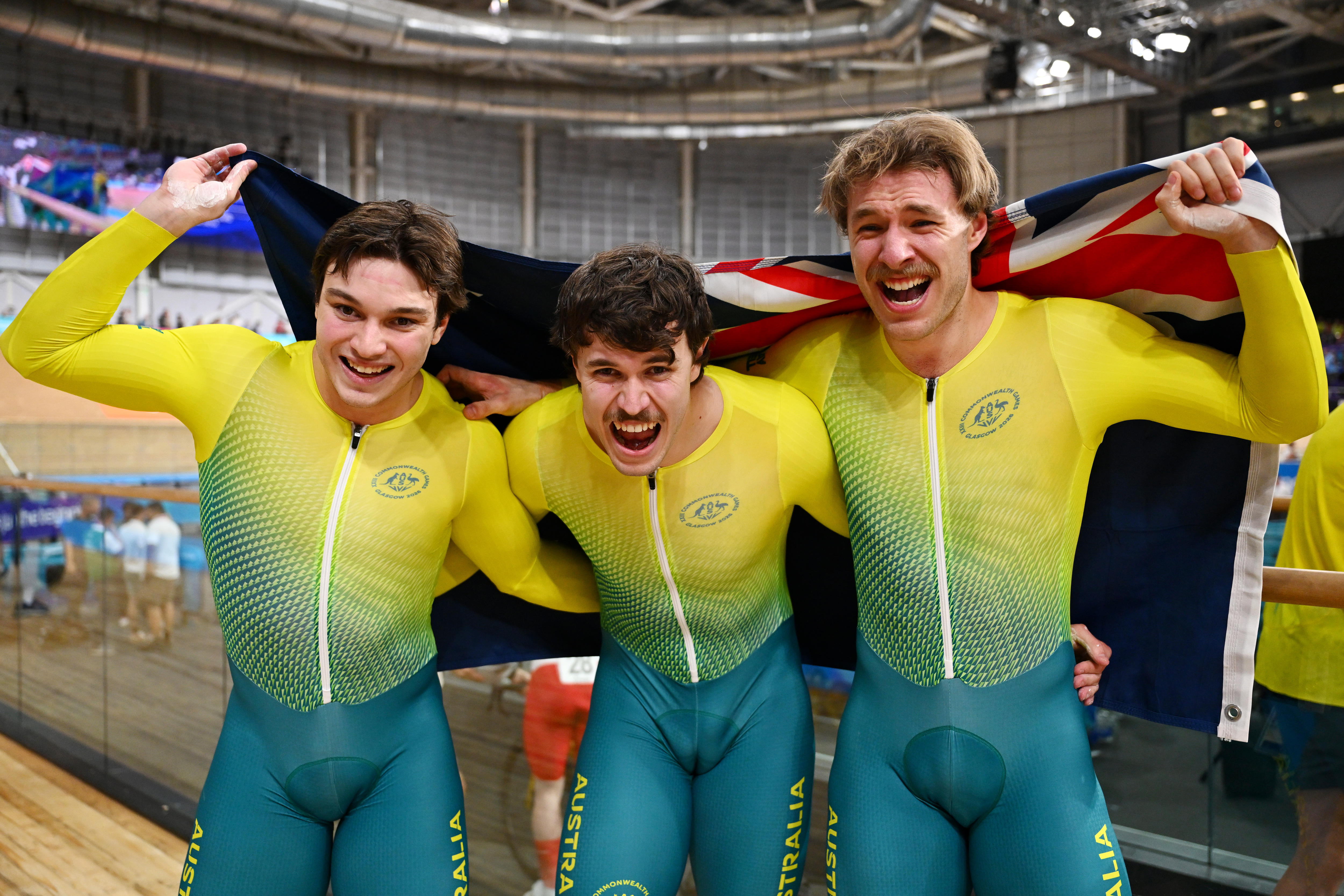 Three athletes in Australian kit celebrate a win at the Games