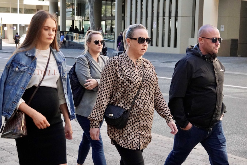 Three women and a man walk along a street in the Perth CBD after leaving court.