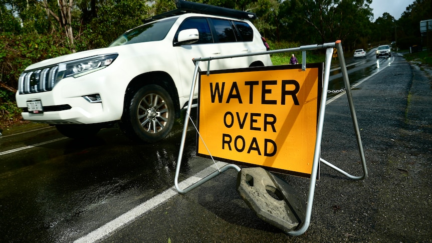 A sign warning of water over the road.