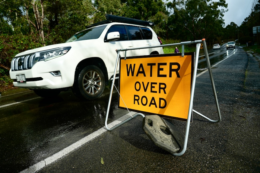 A sign warning of water over the road.
