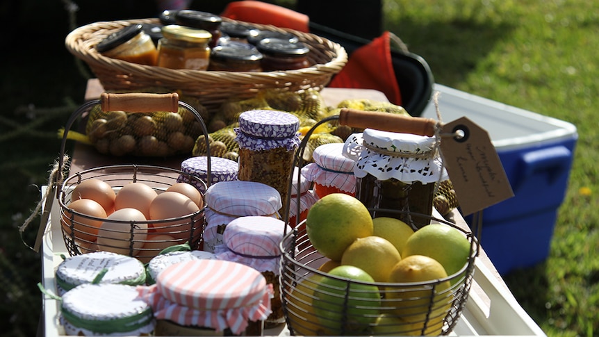 Jams, chutneys and eggs laid out on a table in baskets.