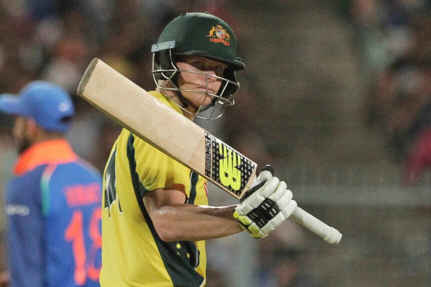 Steve Smith raises his bat to the crowd after reaching a half-century against India in Kolkata.