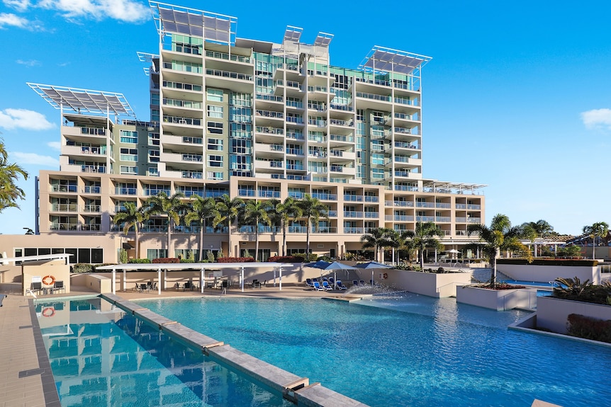 tall resort building with pool in front