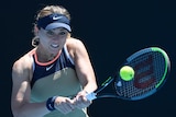 A tennis player watches the ball onto her racquet as she hits a return.