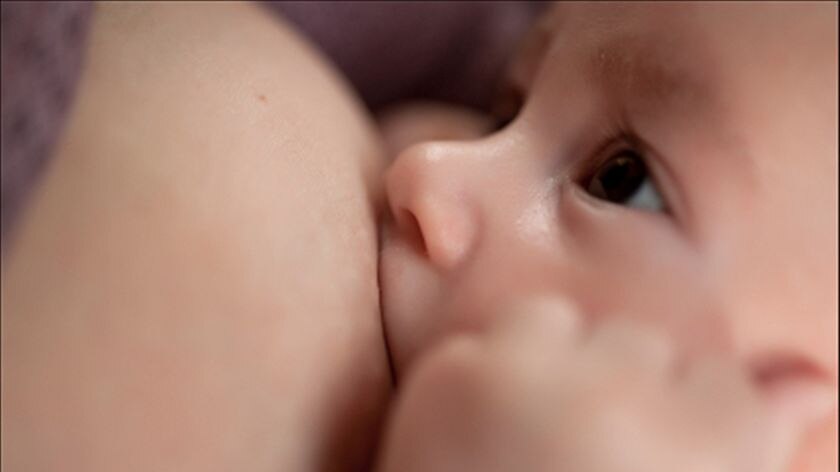 Close up shot of a woman breastfeeding her baby boy.