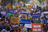 Thousands of people holding Spanish flags and signs marching in Barcelona.