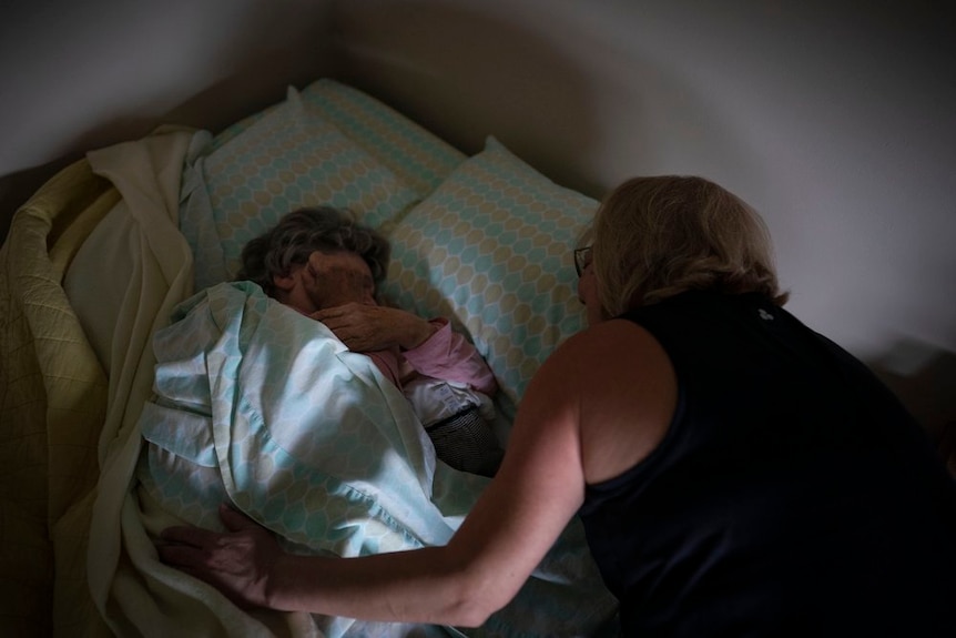 Susan Ryder wakes her mother, Betty Bednarowsk, whos sleeping in bed.
