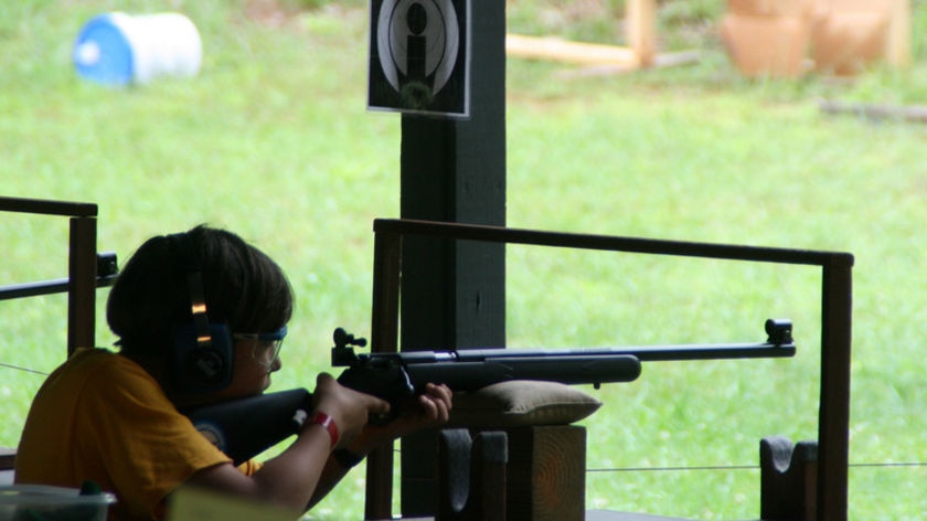 A boy scout shoots at a rifle range