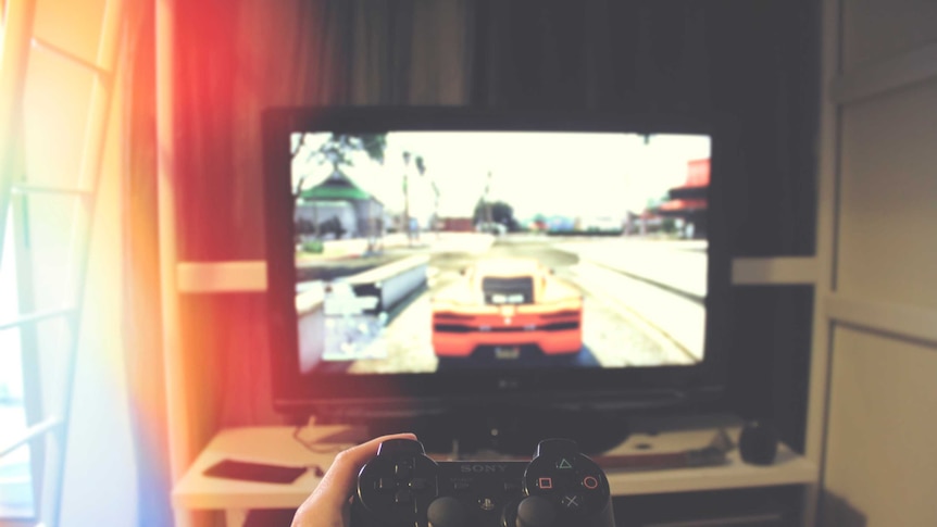 A gamer plays a motoring game on a Sony Playstation console.