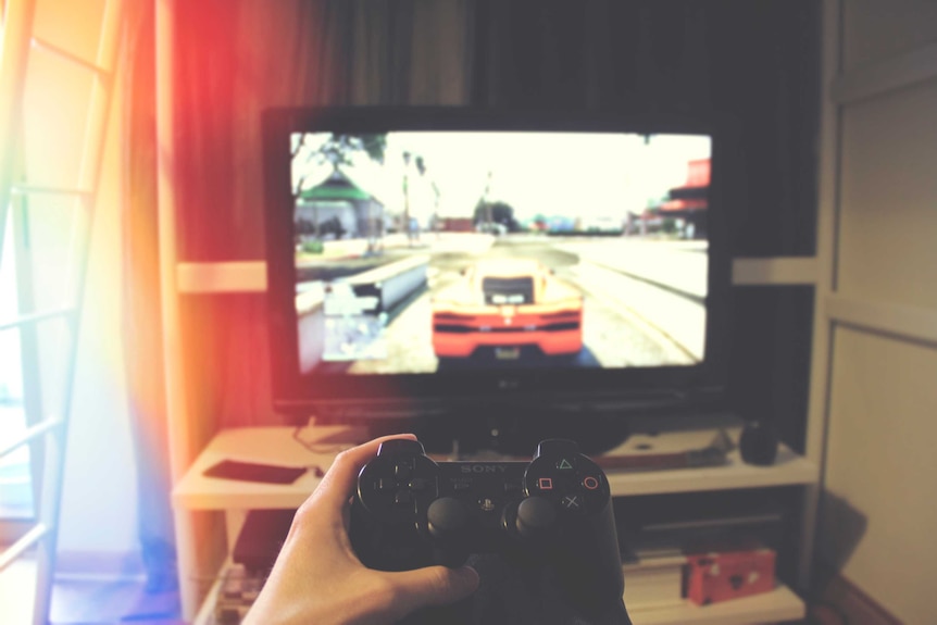 A gamer plays a motoring game on a Sony Playstation console.