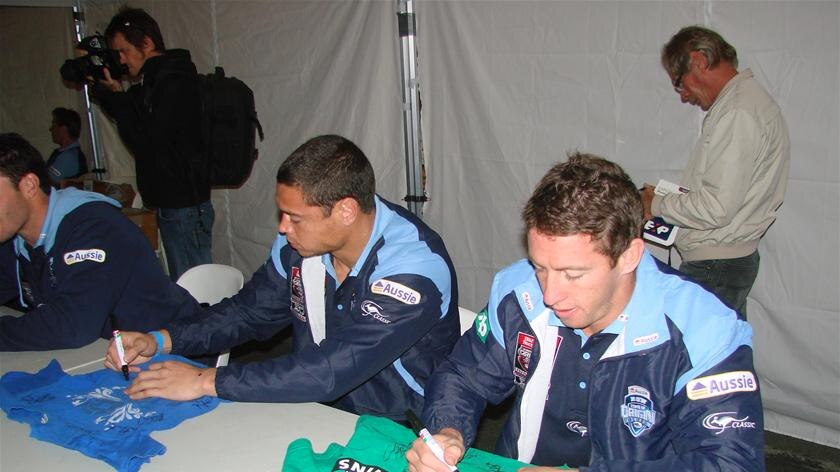 NSW player Timana Tahu (Left) signs autographs at Lennox Head the night before walking out of camp at Cudgen.