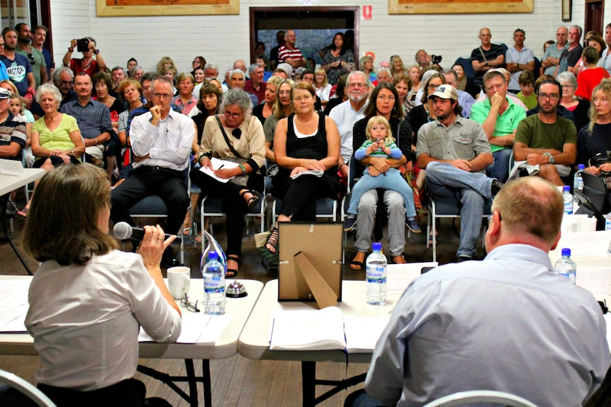 About 200 people sitting in a small community hall listening to mayor Rhonda Hoban