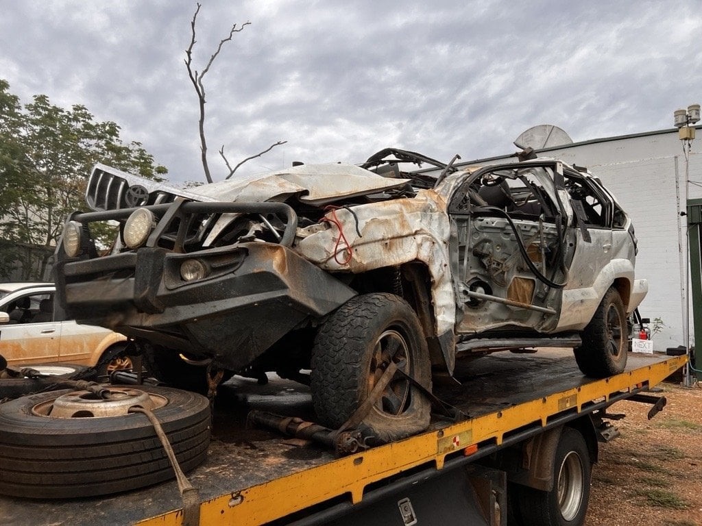 Wreckage of a white Toyota Landcruiser on the back of a tow truck
