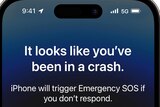 Text on an iPhone screen reads: It looks like you've been in a crash. iPhone will trigger Emergency SOS if you don't respond.