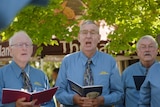 Members of the choir sing from their songbooks 