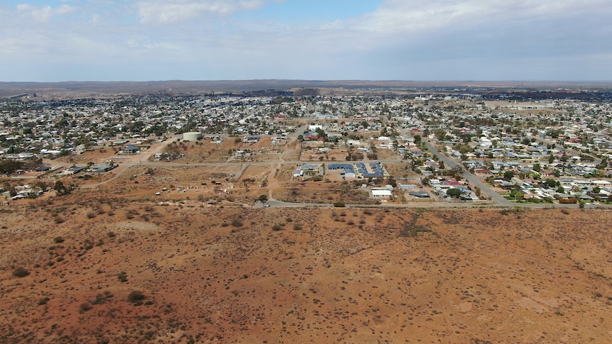 Aerial image of a remote town surrounded by red desert sand