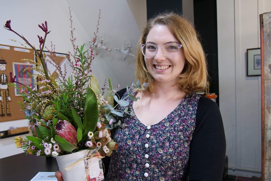Lismore businesswoman Sally Flannery admires the flowers sent by a mystery donor