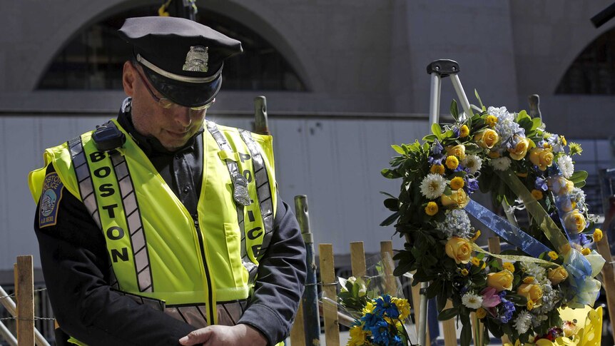 Boston police officer Roy Boussard bows his head