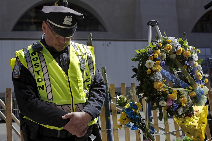 Boston police officer Roy Boussard bows his head