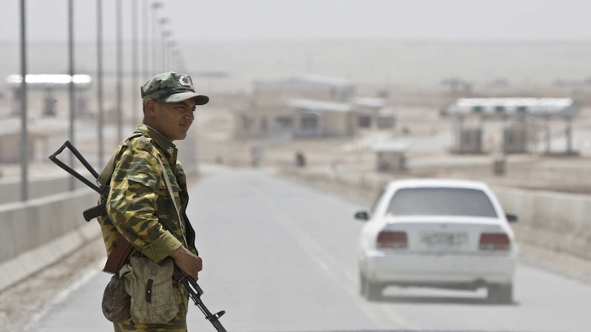 A frontier guard stands on a bridge to Afghanistan across Panj river