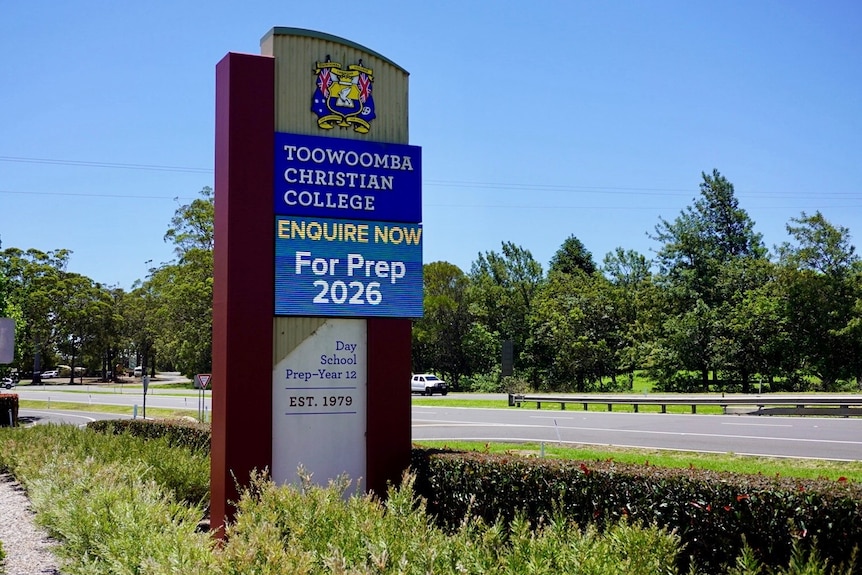 A large school sign reading "Toowoomba Christian College" in front of a road.