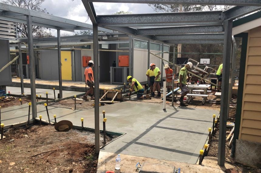 Workmen rebuild a school classroom.