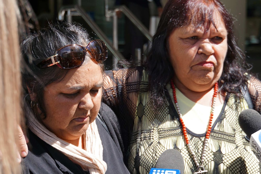 A close up head and shoulders shot of two Aboriginal woman talking to reporters outdoors.