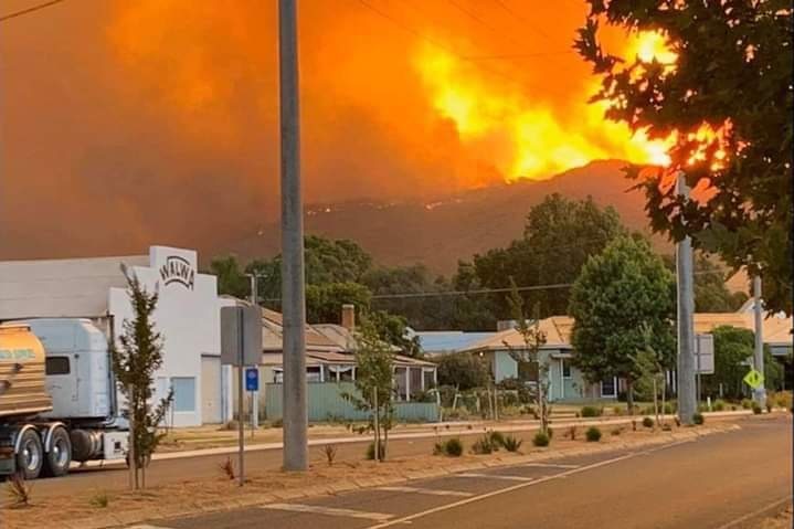 Orange flames can be seen rising over a mountain, from the main street in Walwa.