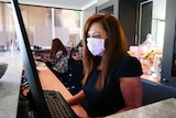 woman standing in reception with mask on