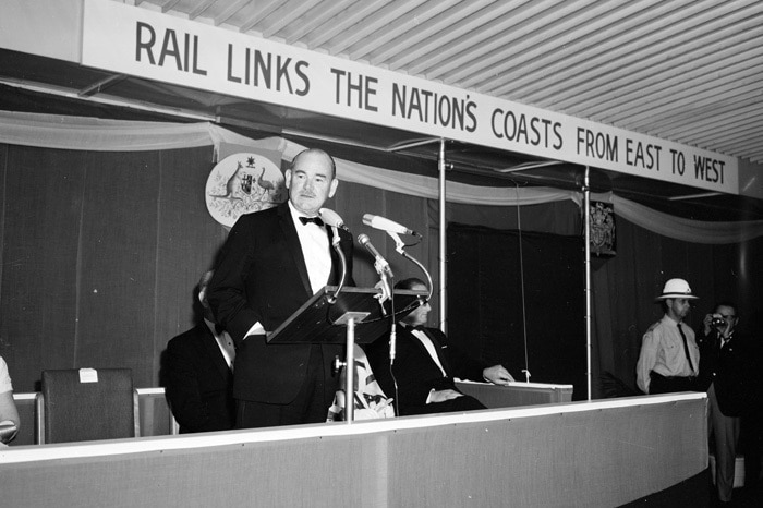 A black and white photograph of the former Governor General speaking on a train platform.