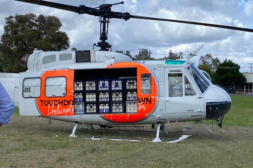 A helicopter filled with cartons of milk landed in a field