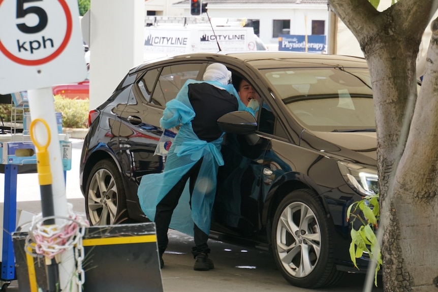 A man gets testing for COVID at a drive through clinic