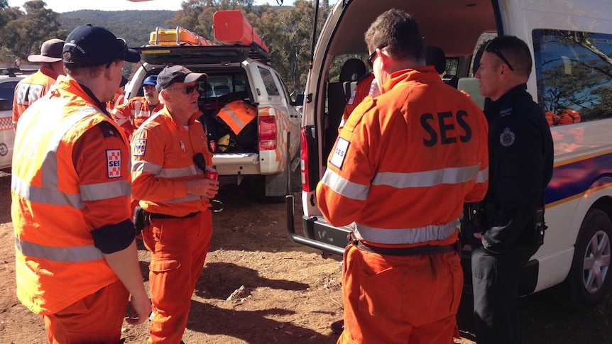 SES volunteers wearing bright orange clothing in bushland.
