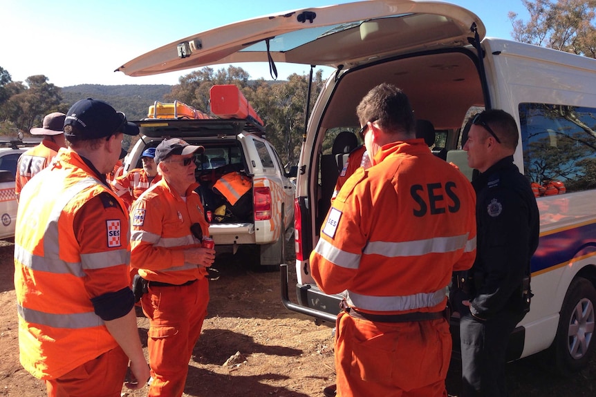 SES volunteers wearing bright orange clothing in bushland.