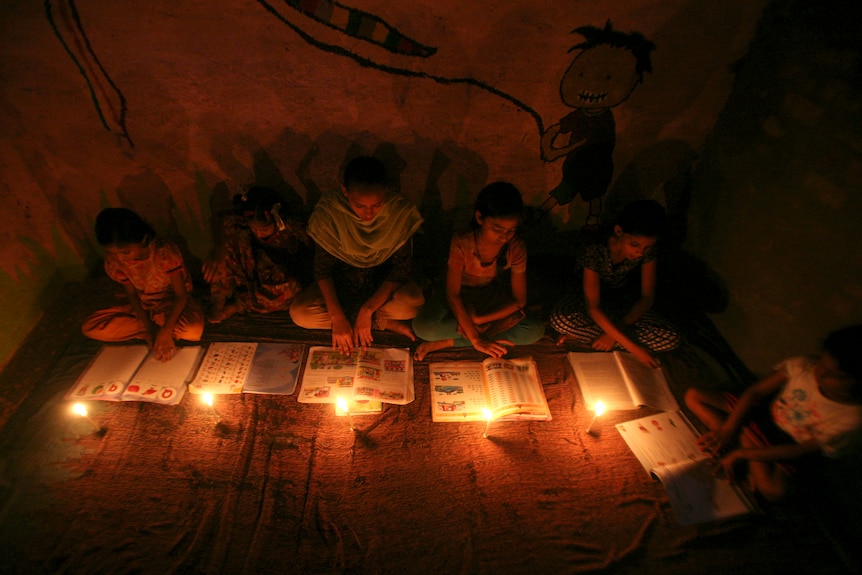 Muslim girls study in the light of candles inside a madrasa during a power-cut in Noida on the outskirts of New Delhi.
