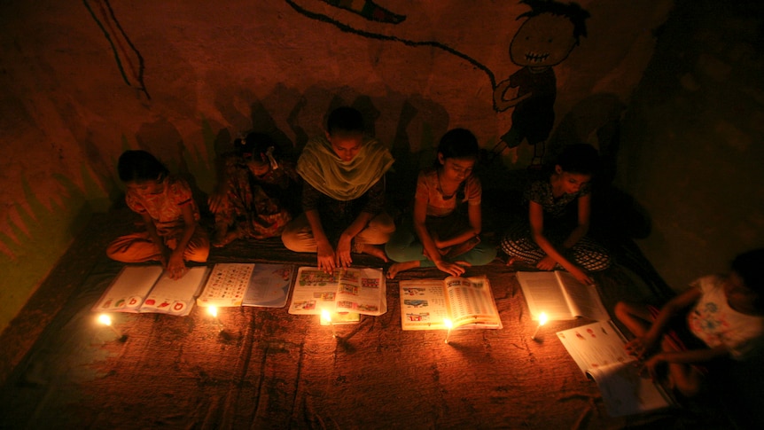 Muslim girls study in the light of candles during a power-cut on the outskirts of New Delhi.